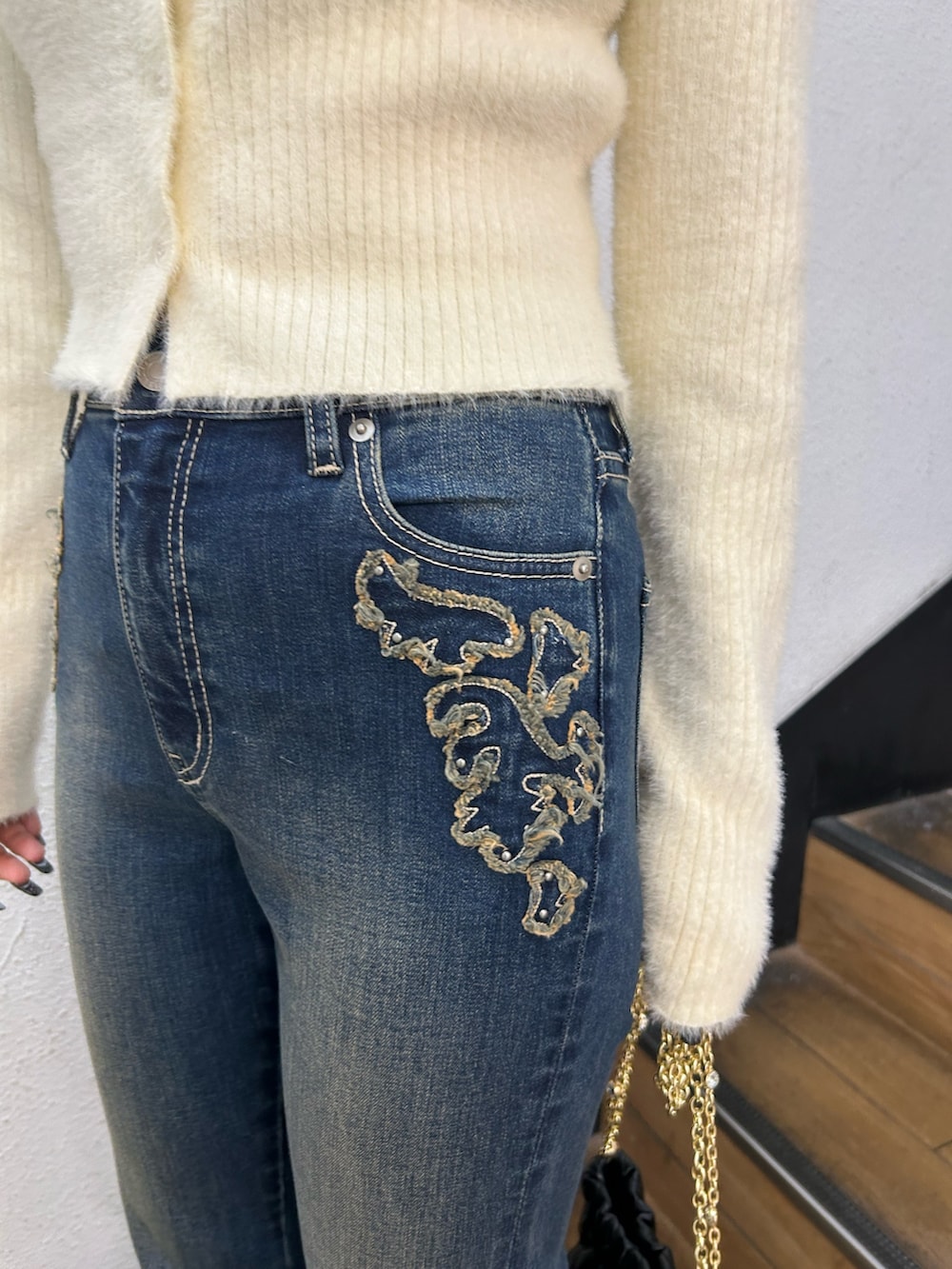 ホワイト系のニット/セーター、ブラック系のショルダーバッグ、ブルー系のデニムパンツを着用したレディースの秋コーディネートの7枚目の写真