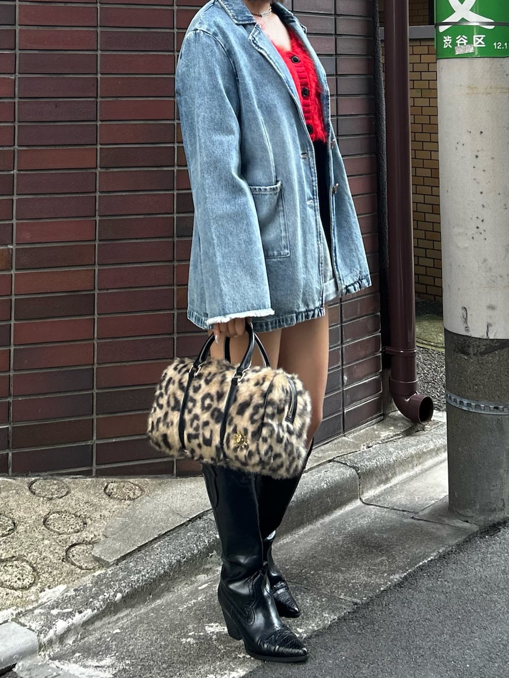 レッド系のニット/セーター、ブルー系のデニムジャケット、ブルー系のデニムパンツを着用したレディースの夏コーディネートの2枚目の写真