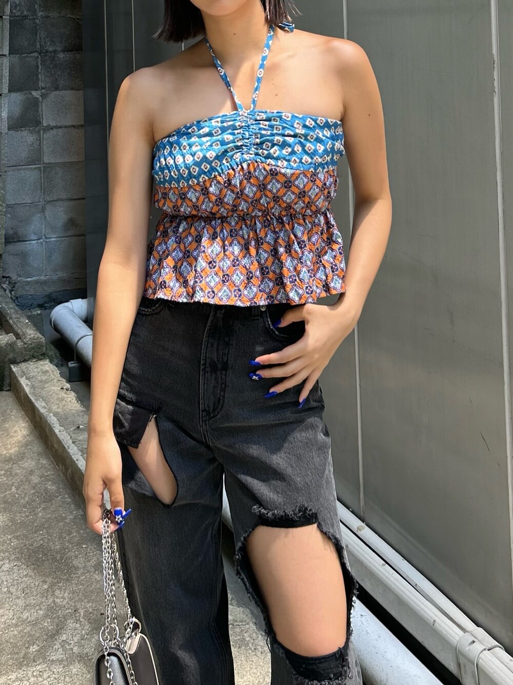 ブルー系のキャミソール、ホワイト系のサンダル、ブラック系のデニムパンツを着用したレディースの夏コーディネートの3枚目の写真