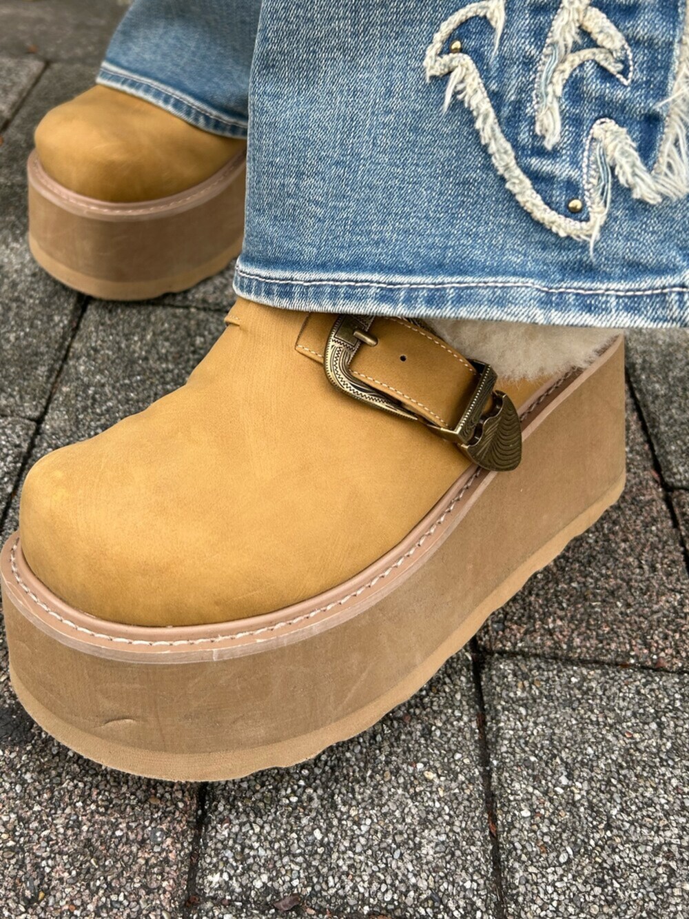 ブラウン系のニット/セーター、ベージュ系のスリッポン、ブルー系のデニムパンツを着用したレディースの秋コーディネートの10枚目の写真