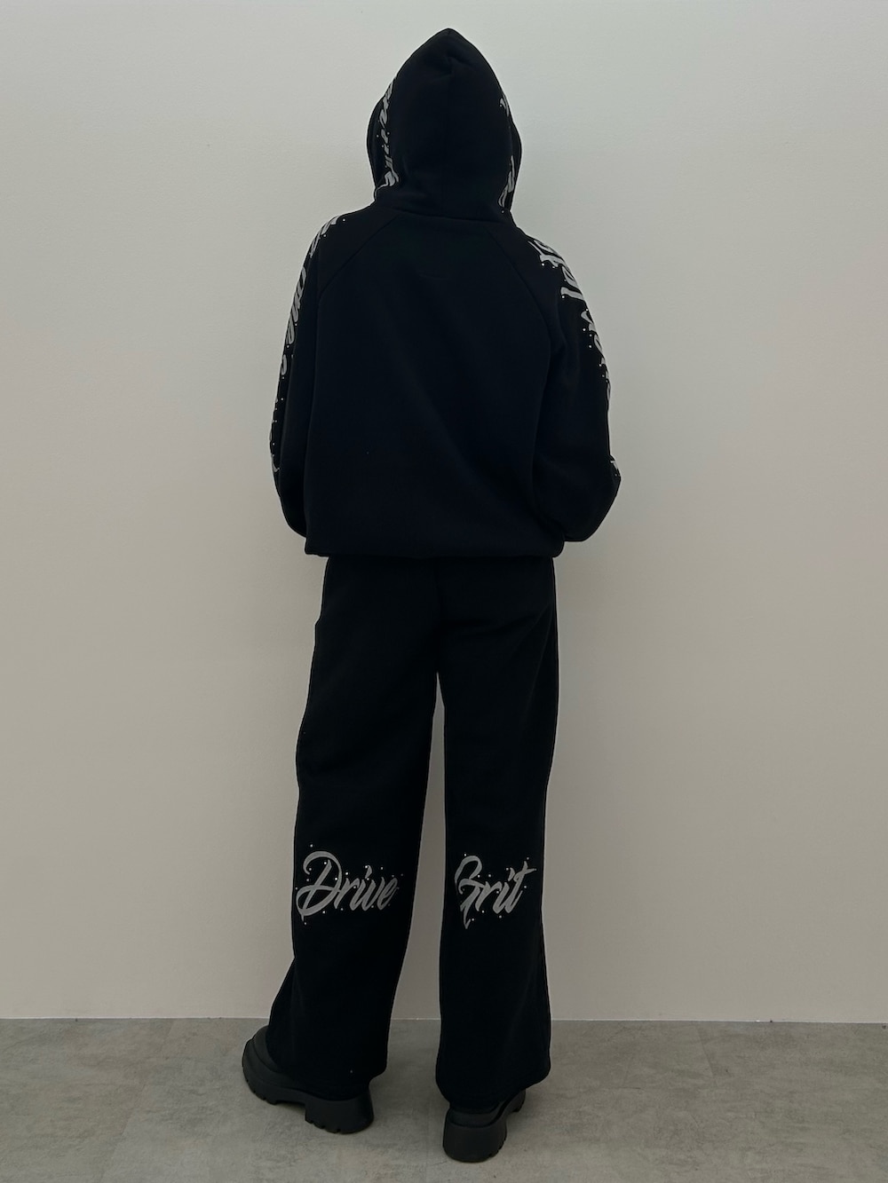 ブラック系のパーカー、ブラック系のブーツを着用したレディースの秋コーディネートの3枚目の写真