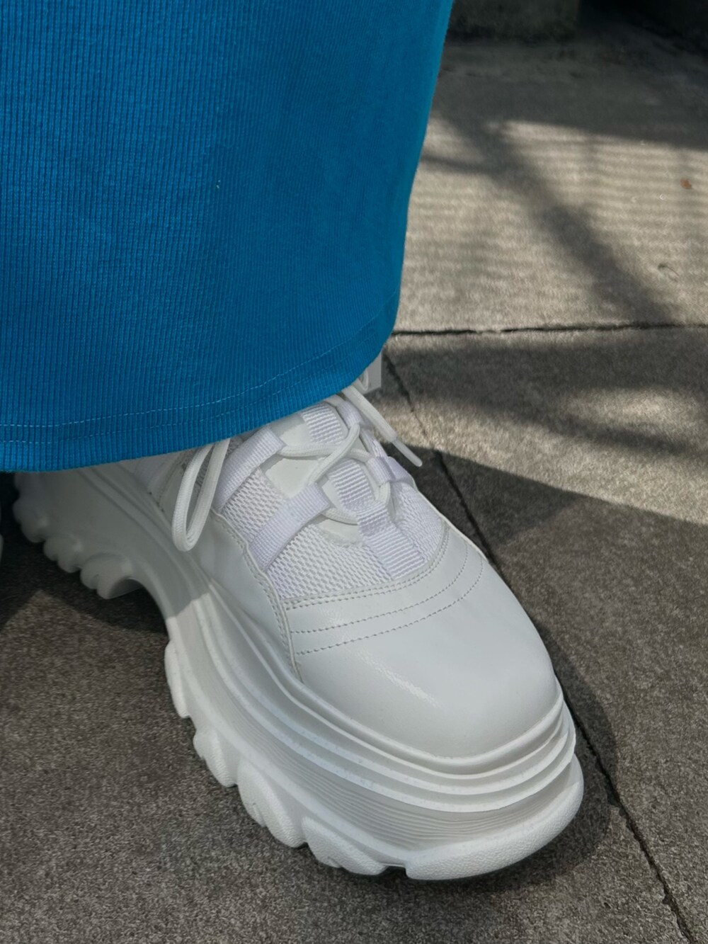 ブルー系のワンピース、ホワイト系のショルダーバッグ、ホワイト系のスニーカーを着用したレディースの春コーディネートの5枚目の写真