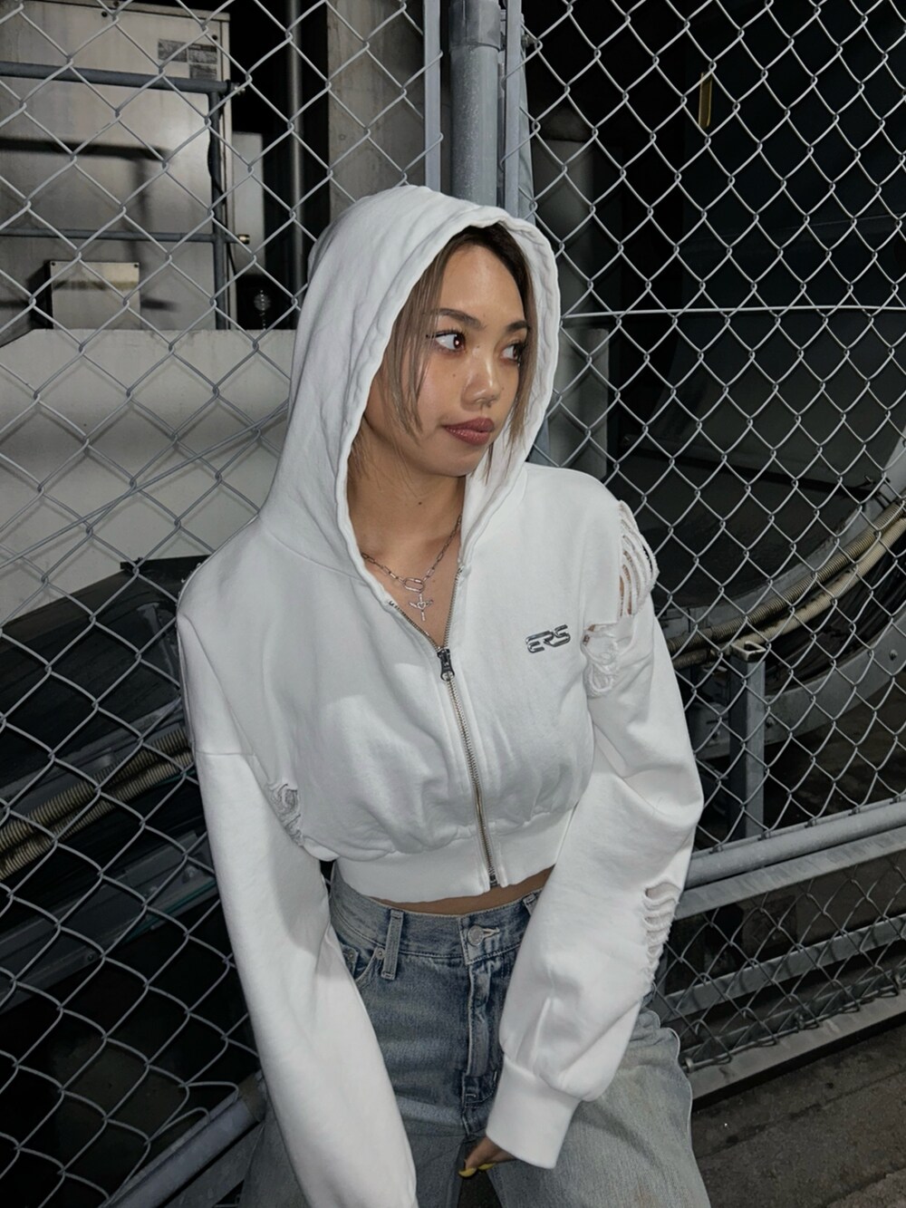 ブルー系のデニムパンツ、ホワイト系のパーカー、ブラック系のブーツを着用したレディースの春コーディネートの2枚目の写真