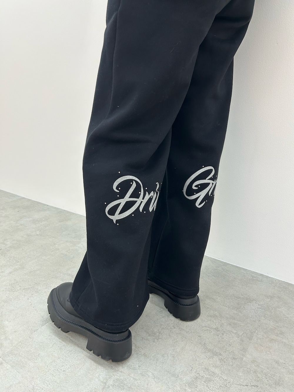 ブラック系のパーカー、ブラック系のブーツを着用したレディースの秋コーディネートの5枚目の写真