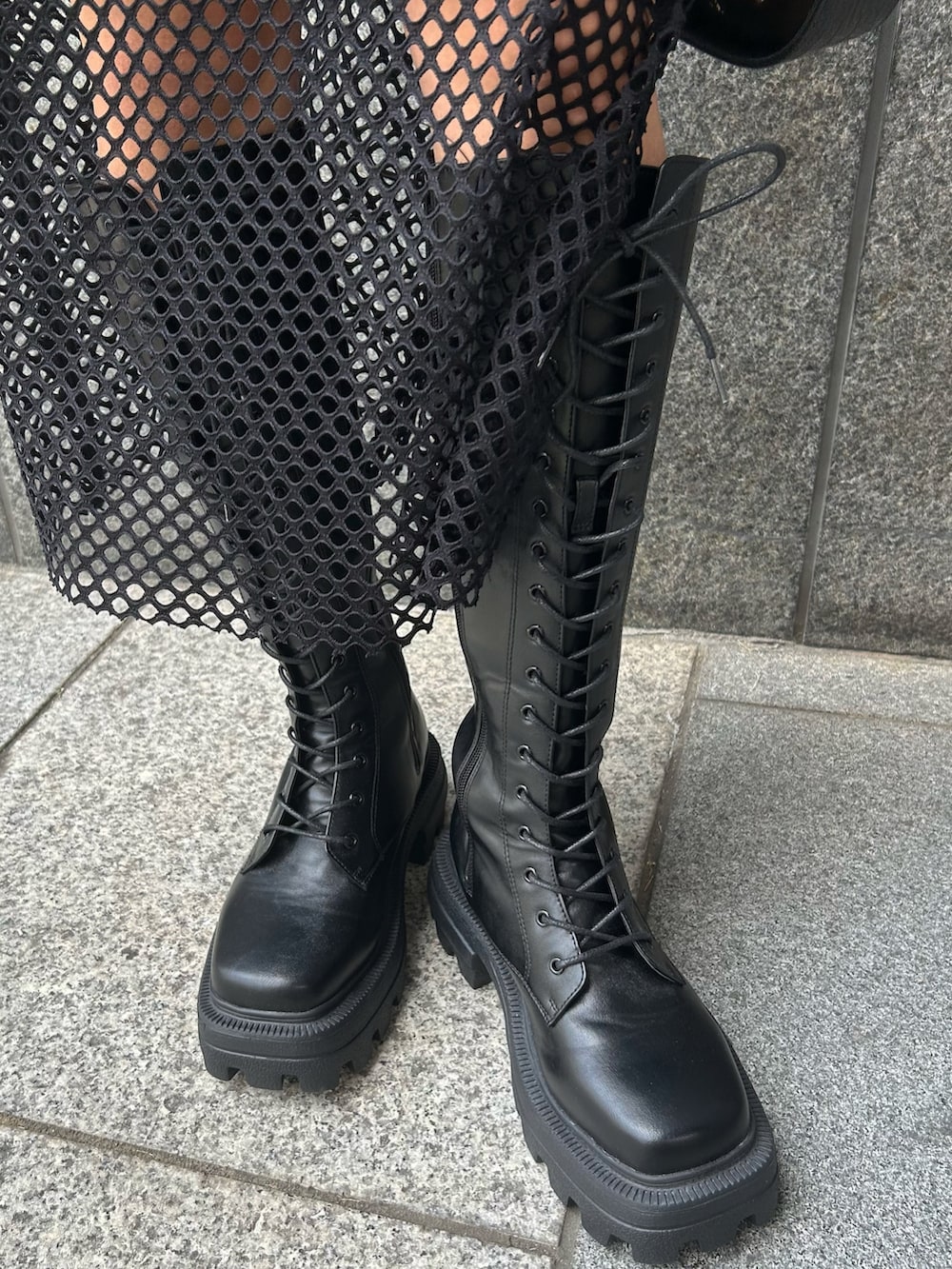 ブラック系のワンピース、ブラック系のハンドバッグ、ブラック系のブーツを着用したレディースの夏コーディネートの4枚目の写真