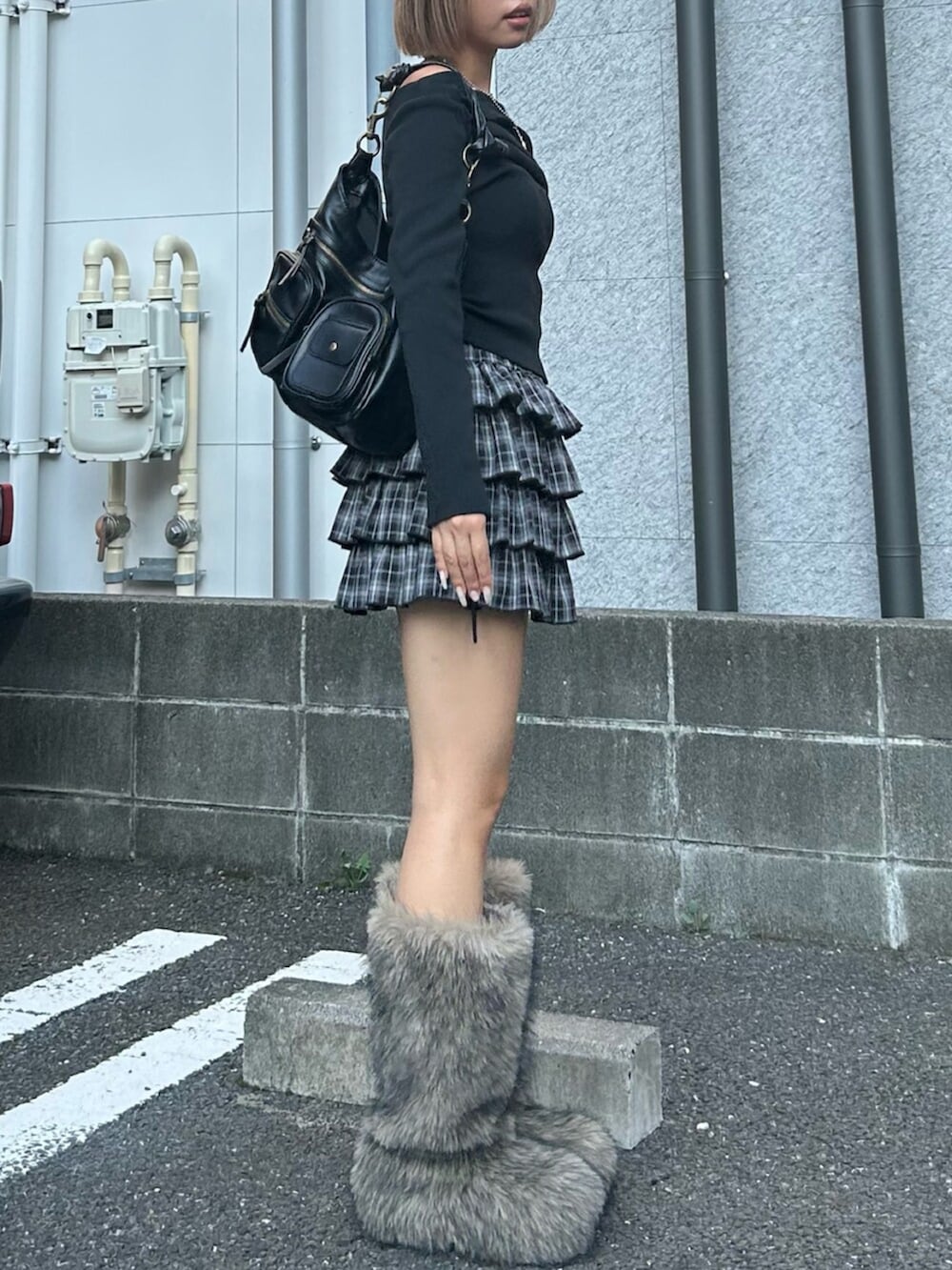 ブラック系のハンドバッグ、ブラック系のスカート、ブラック系のニット/セーターを着用したレディースの秋コーディネートの3枚目の写真