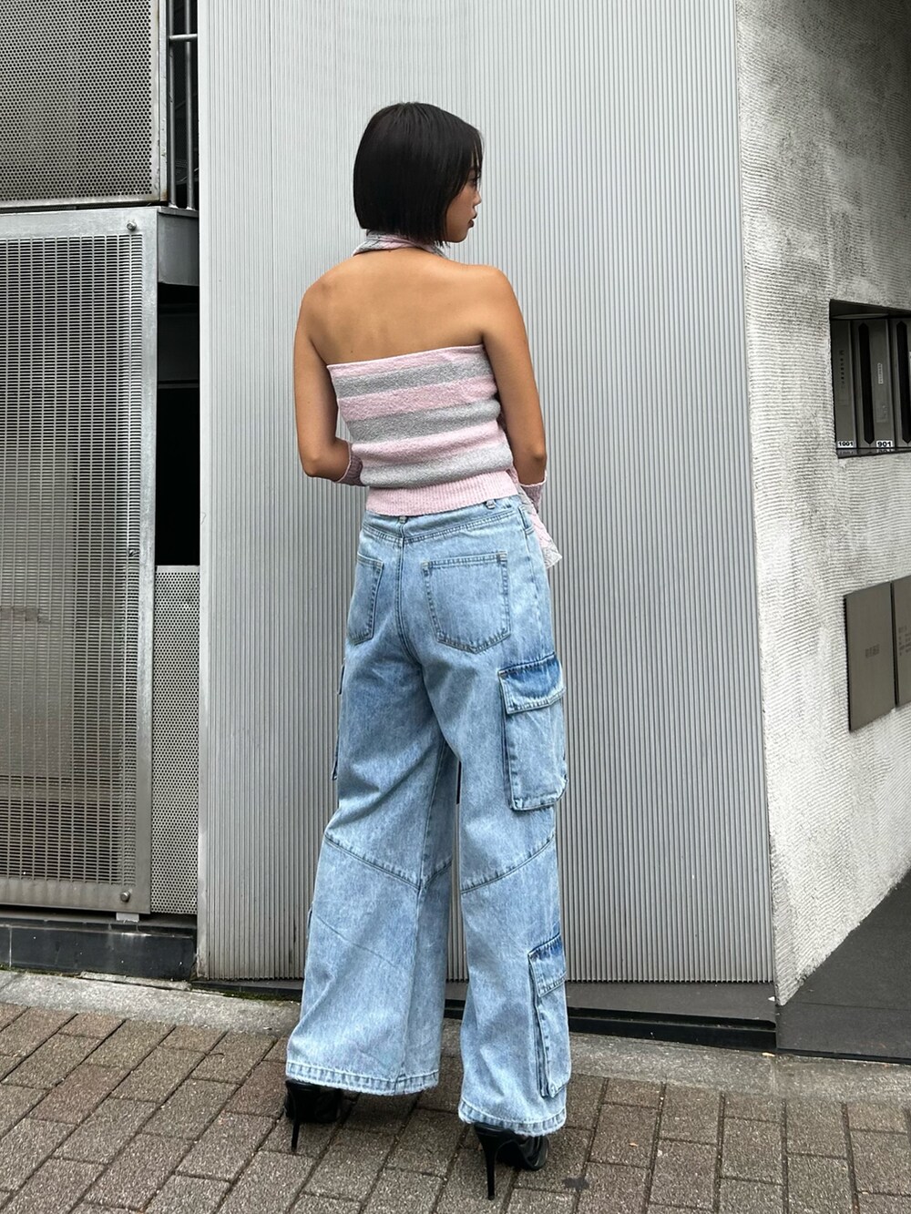 ピンク系のニット/セーター、ブルー系のデニムパンツ、ブラック系のショルダーバッグを着用したレディースの秋コーディネートの2枚目の写真