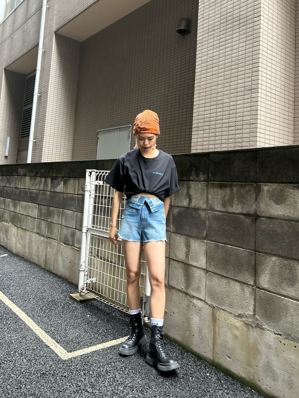 ブルー系のデニムパンツ、ブラック系のTシャツ/カットソー、ブラック系のブーツを着用したレディースの春コーディネートの2枚目の写真