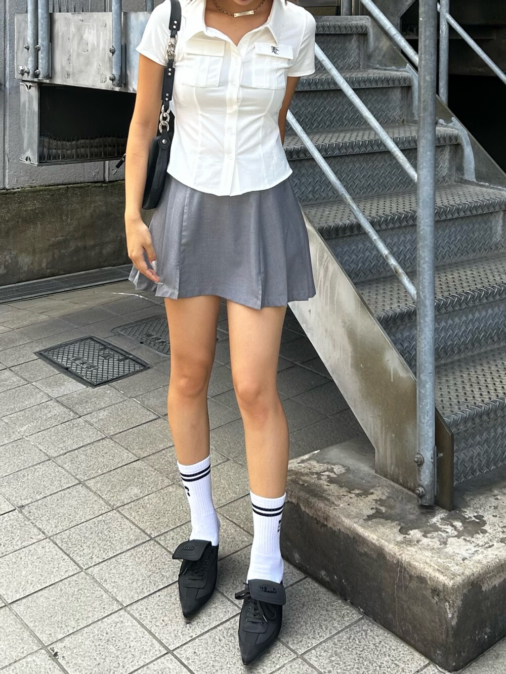 グレー系のスカート、ホワイト系のシャツ/ブラウス、ホワイト系のソックス/靴下を着用したレディースの夏コーディネートの2枚目の写真