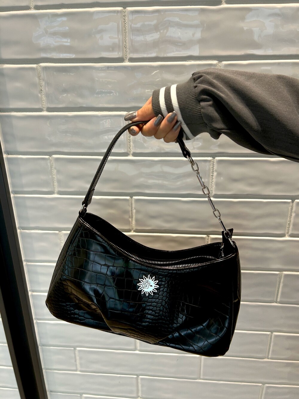 グレー系のテーラードジャケット、グレー系のスカート、ブラック系のハンドバッグを着用したレディースの秋コーディネートの5枚目の写真