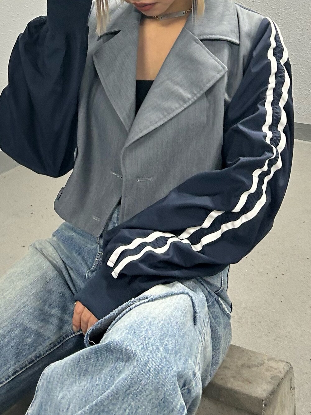 ブルー系のデニムパンツ、シルバー系のサンダル、グレー系のテーラードジャケットを着用したレディースの冬コーディネートの2枚目の写真