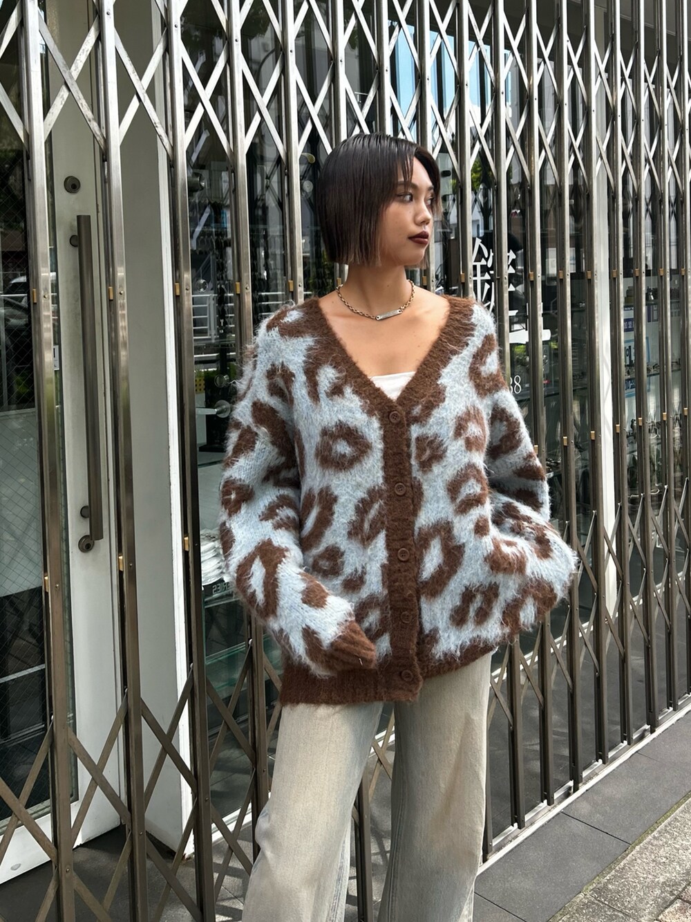 ブルー系のデニムパンツ、ブラック系のパンプス、ブルー系のニット/セーターを着用したレディースの秋コーディネートの3枚目の写真