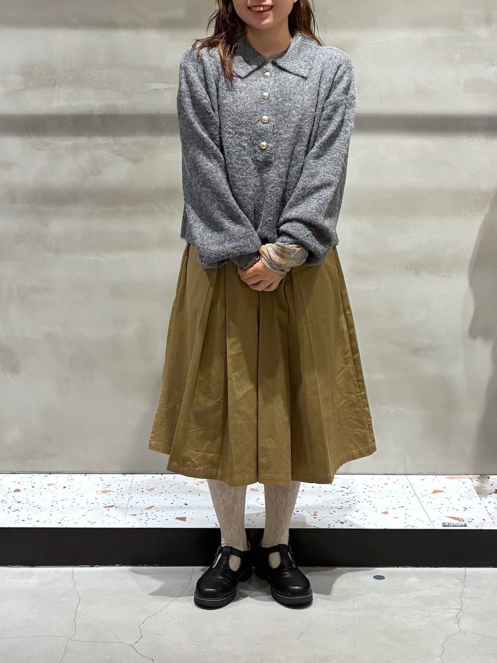 ベージュ系のチノパンツ、グレー系のニット/セーター、イエロー系のTシャツ/カットソーを着用したレディースの秋コーディネートの2枚目の写真