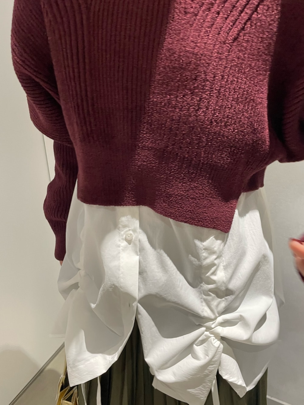 ブラウン系のニット/セーター、ホワイト系のシャツ/ブラウス、グリーン系のスカートを着用したレディースの冬コーディネートの5枚目の写真