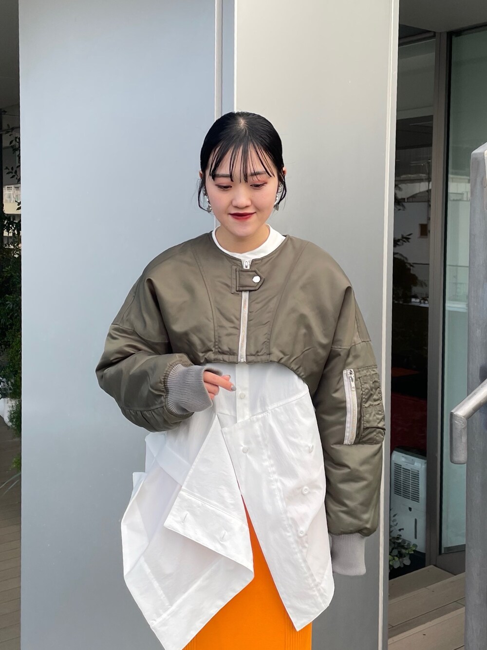 グリーン系のMA-1、ホワイト系のシャツ/ブラウス、シルバー系のブーツを着用したレディースの冬コーディネートの5枚目の写真