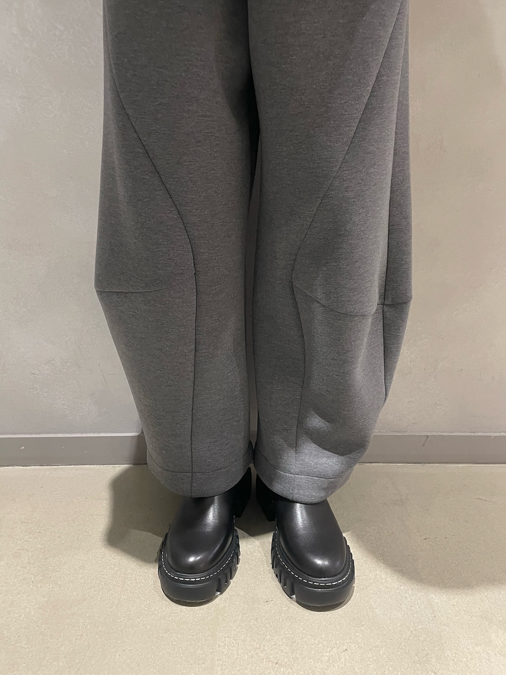 グレー系のニット/セーター、グレー系のTシャツ/カットソー、ブルー系のショルダーバッグを着用したレディースの秋コーディネートの7枚目の写真