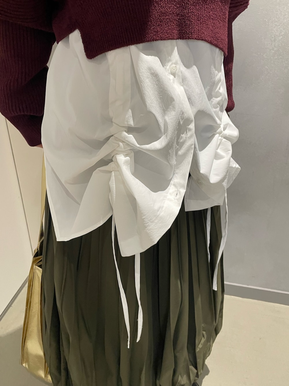 ブラウン系のニット/セーター、ホワイト系のシャツ/ブラウス、グリーン系のスカートを着用したレディースの冬コーディネートの6枚目の写真