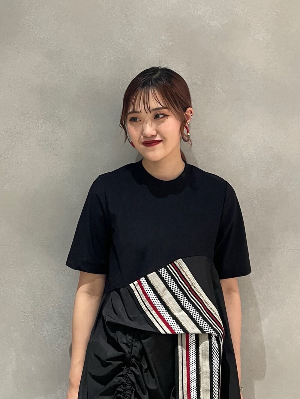 レッド系のTシャツ/カットソー、レッド系のスカート、ブラック系のブーツを着用したレディースの夏コーディネートの4枚目の写真