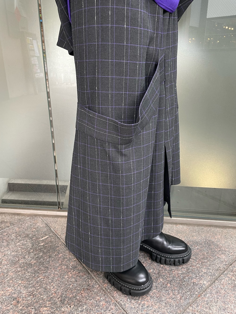 グレー系のスカート、ブラック系のブーツ、パープル系のニット/セーターを着用したレディースの秋コーディネートの8枚目の写真