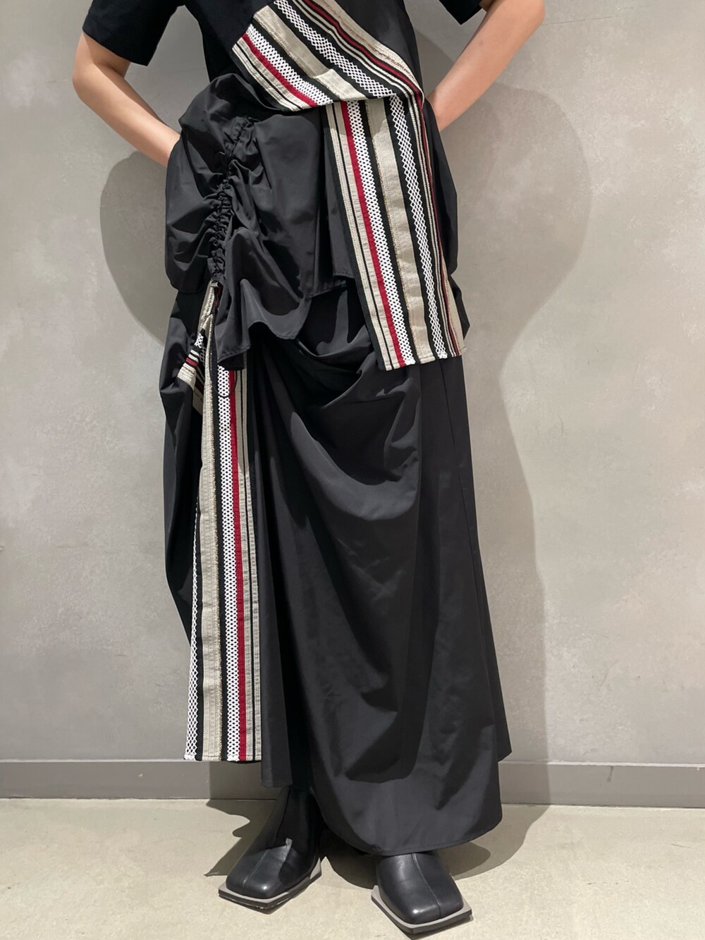 レッド系のTシャツ/カットソー、レッド系のスカート、ブラック系のブーツを着用したレディースの夏コーディネートの8枚目の写真