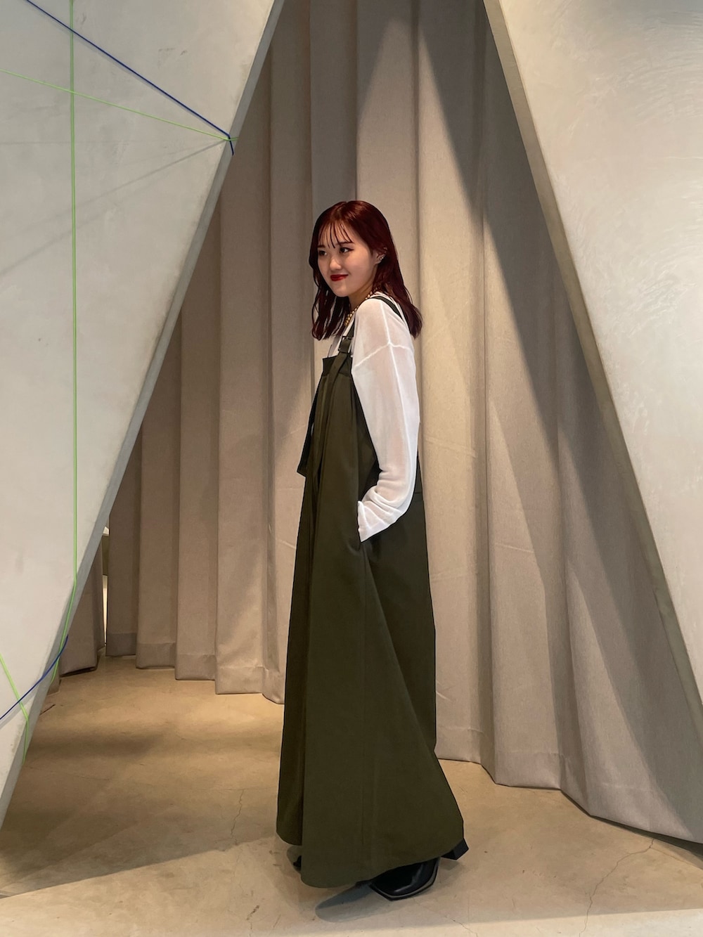 ベージュ系のつなぎ/オールインワン、ホワイト系のニット/セーター、ブラック系のブーツを着用したレディースの夏コーディネートの2枚目の写真