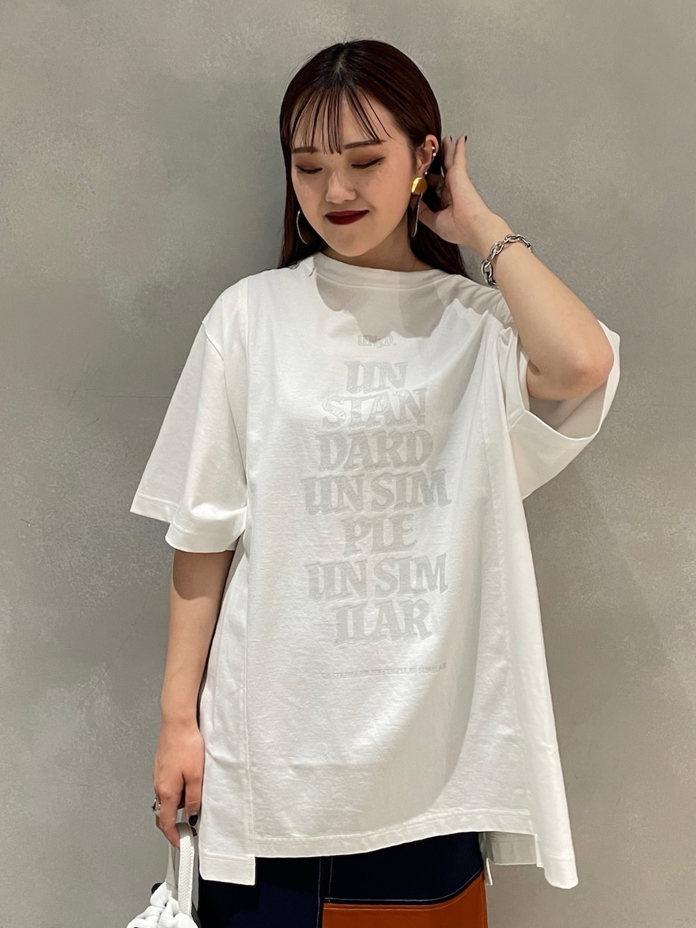 ホワイト系のTシャツ/カットソー、ホワイト系のバックパック/リュック、オレンジ系のスカートを着用したレディースの夏コーディネートの4枚目の写真