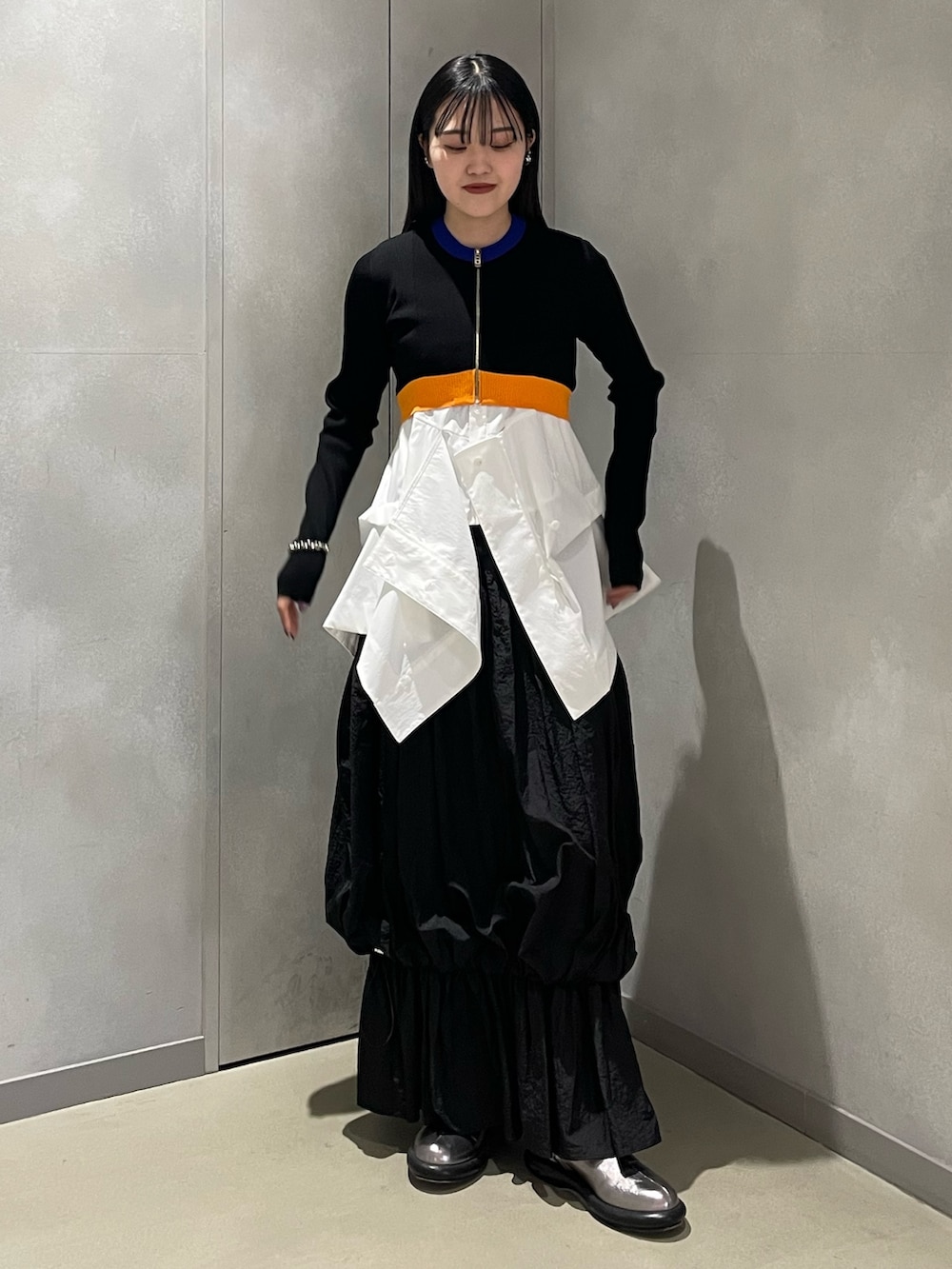 ブラック系のカーディガン/ボレロ、ホワイト系のシャツ/ブラウス、ブラック系のスカートを着用したレディースの春コーディネートの2枚目の写真