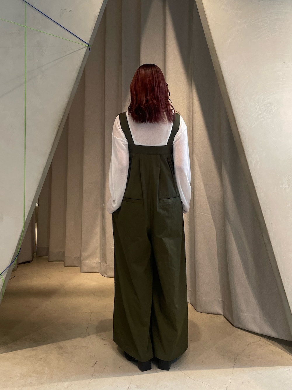 ベージュ系のつなぎ/オールインワン、ホワイト系のニット/セーター、ブラック系のブーツを着用したレディースの夏コーディネートの3枚目の写真