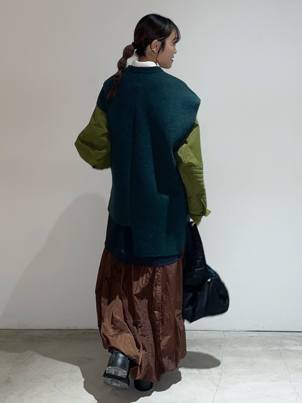 グリーン系のニット/セーター、その他のシャツ/ブラウス、ブラック系のハンドバッグを着用したレディースの秋コーディネートの2枚目の写真