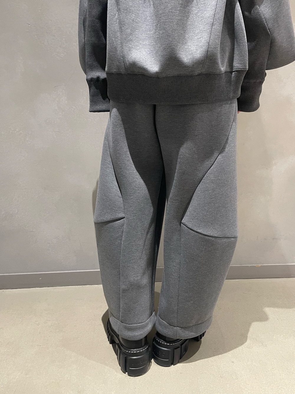 グレー系のニット/セーター、グレー系のTシャツ/カットソー、ブルー系のショルダーバッグを着用したレディースの秋コーディネートの9枚目の写真