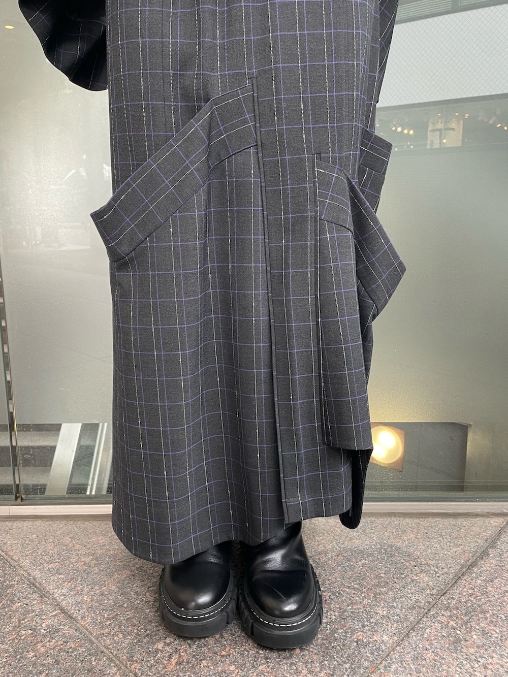 グレー系のスカート、ブラック系のブーツ、パープル系のニット/セーターを着用したレディースの秋コーディネートの7枚目の写真