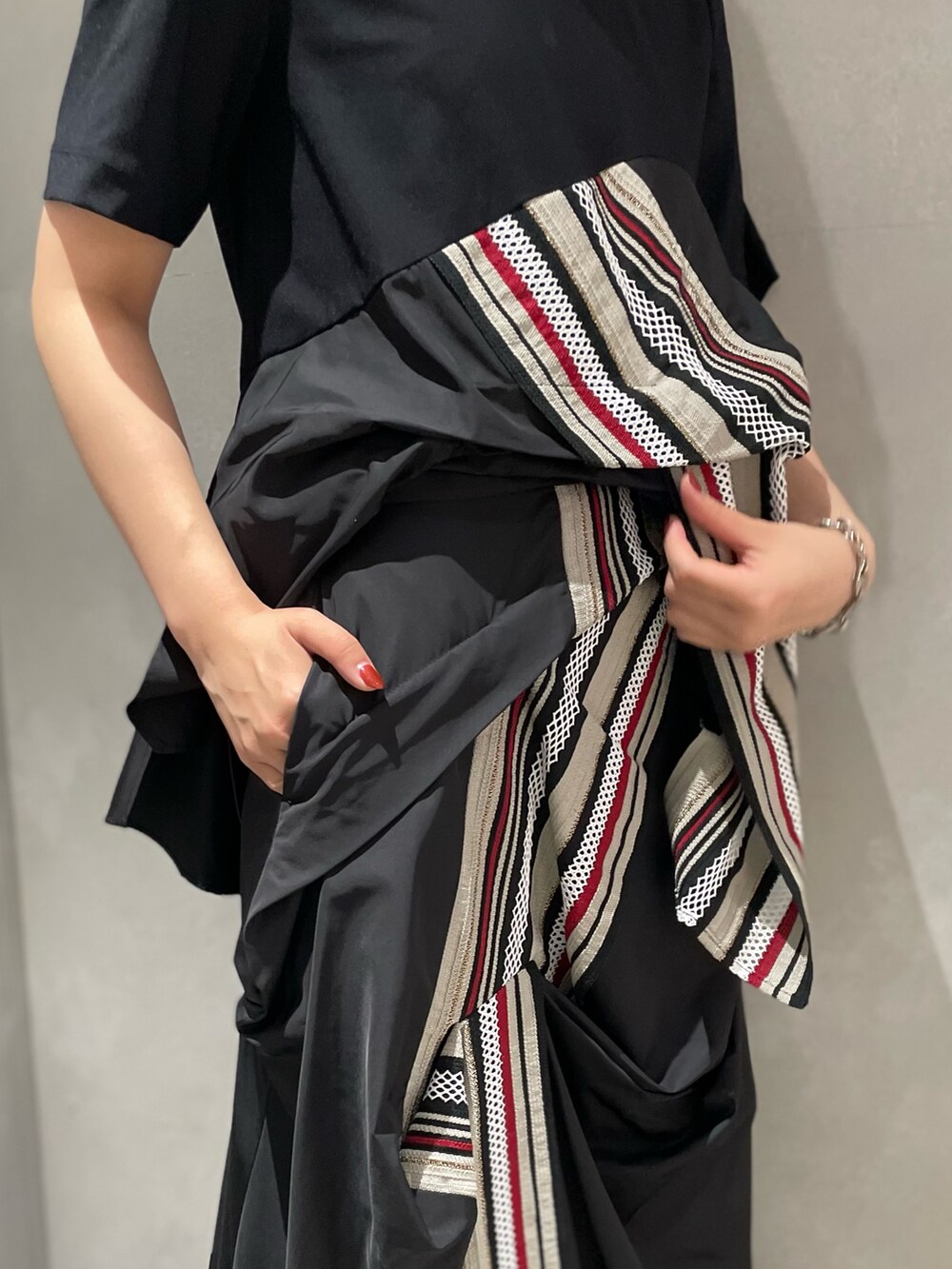 レッド系のTシャツ/カットソー、レッド系のスカート、ブラック系のブーツを着用したレディースの夏コーディネートの6枚目の写真