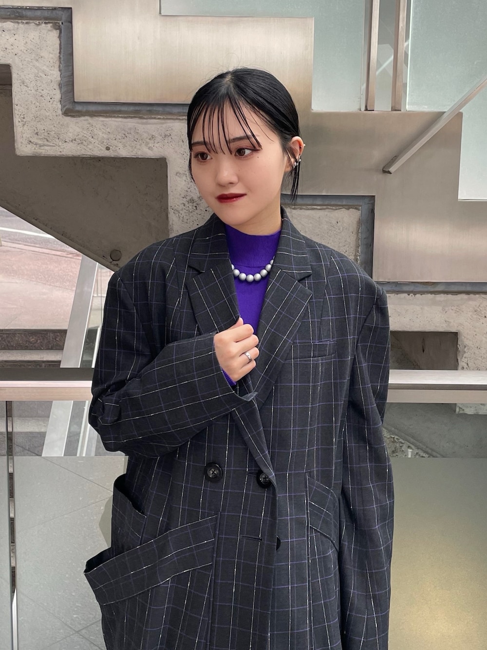 グレー系のスカート、ブラック系のブーツ、パープル系のニット/セーターを着用したレディースの秋コーディネートの4枚目の写真