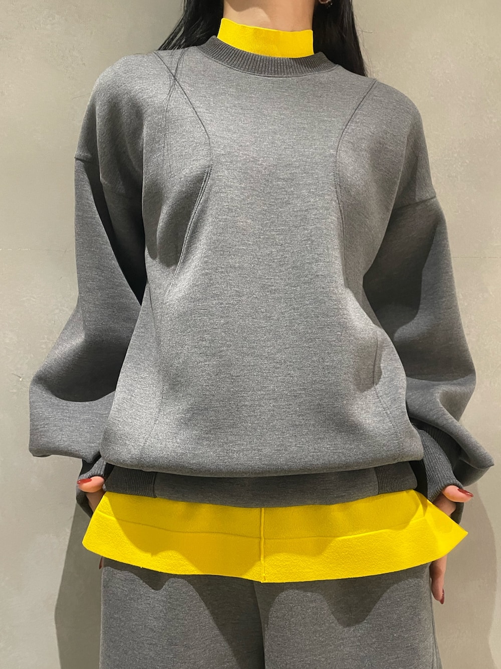 グレー系のニット/セーター、グレー系のTシャツ/カットソー、ブルー系のショルダーバッグを着用したレディースの秋コーディネートの6枚目の写真