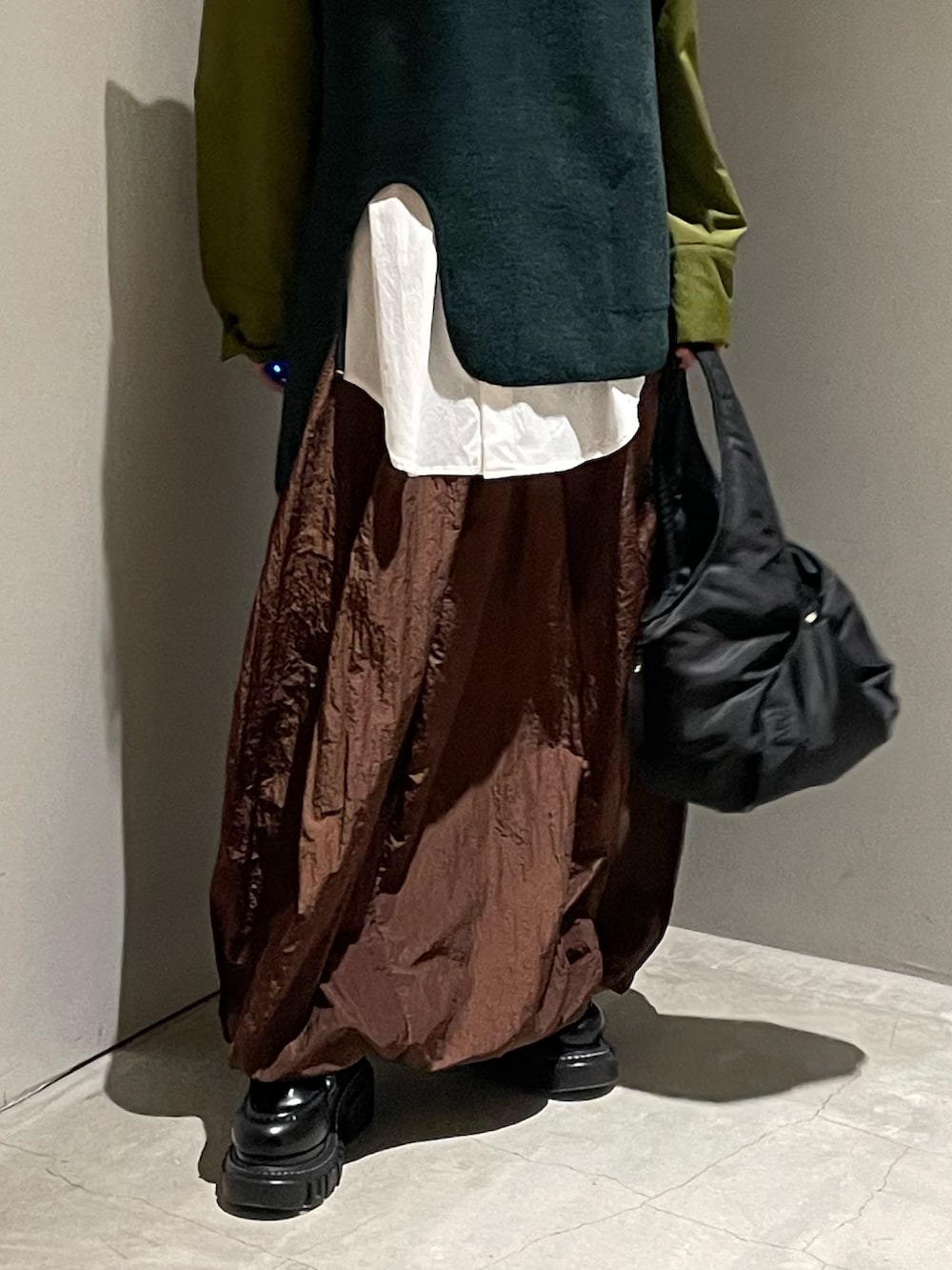 グリーン系のニット/セーター、その他のシャツ/ブラウス、ブラック系のハンドバッグを着用したレディースの秋コーディネートの6枚目の写真