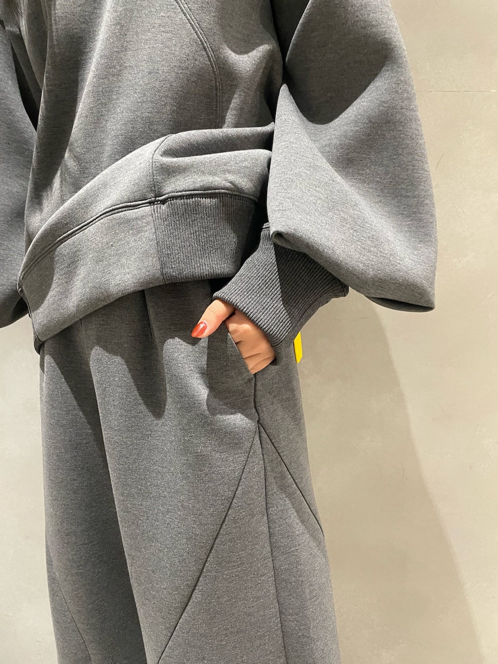 グレー系のニット/セーター、グレー系のTシャツ/カットソー、ブルー系のショルダーバッグを着用したレディースの秋コーディネートの8枚目の写真