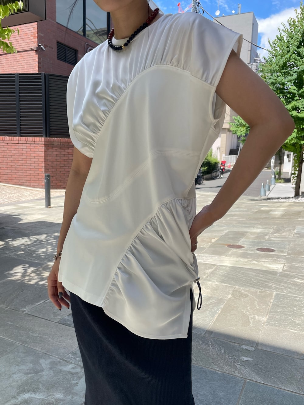 ホワイト系のTシャツ/カットソー、ブルー系のスカート、ブラック系のサンダルを着用したレディースの夏コーディネートの4枚目の写真