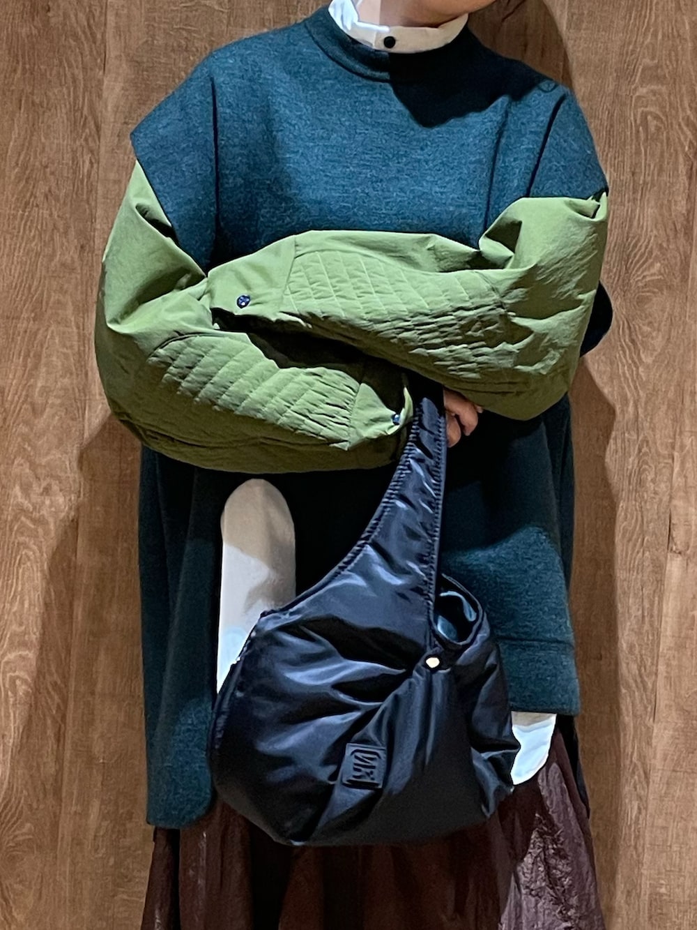 グリーン系のニット/セーター、その他のシャツ/ブラウス、ブラック系のハンドバッグを着用したレディースの秋コーディネートの7枚目の写真