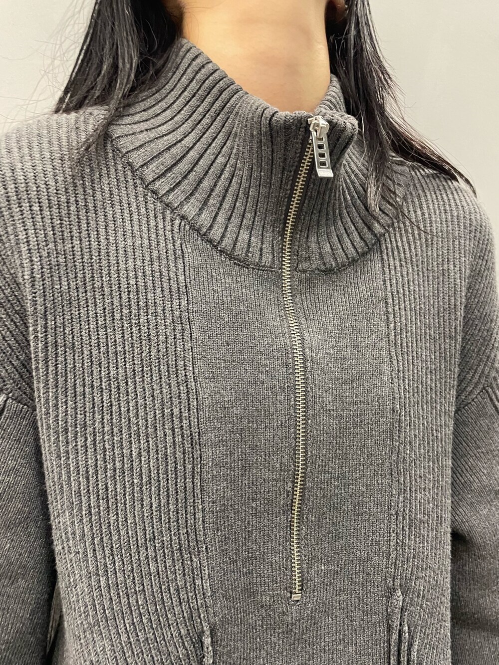 グレー系のニット/セーター、グレー系のスカート、ブラック系のブーツを着用したレディースの秋コーディネートの4枚目の写真