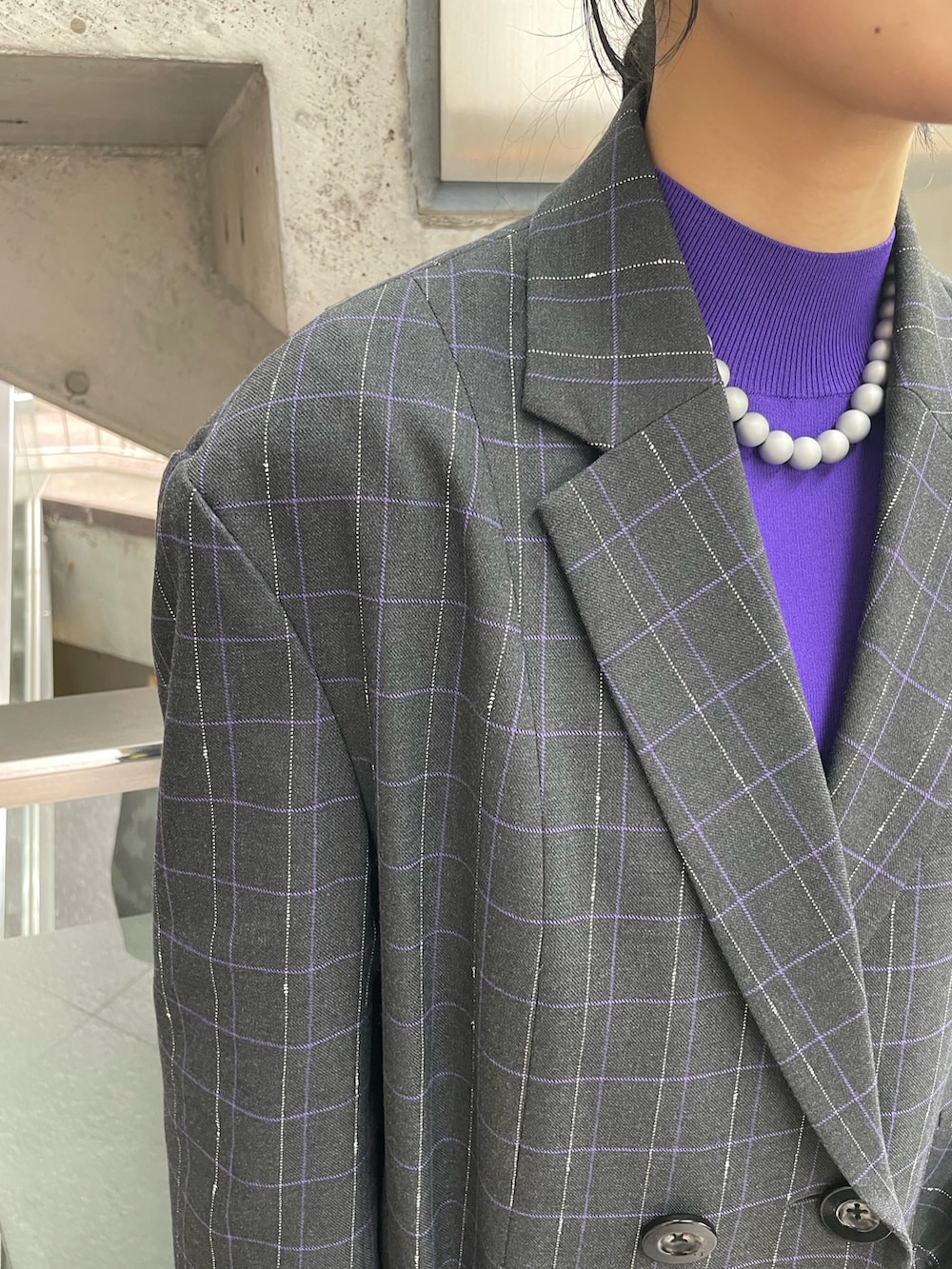 グレー系のスカート、ブラック系のブーツ、パープル系のニット/セーターを着用したレディースの秋コーディネートの5枚目の写真