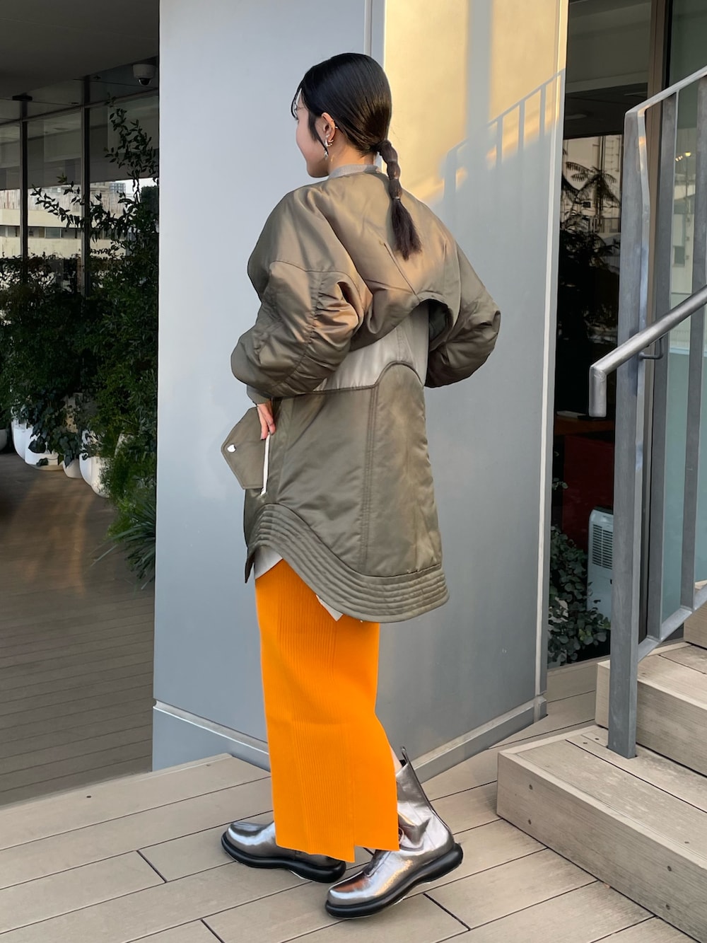 グリーン系のMA-1、ホワイト系のシャツ/ブラウス、シルバー系のブーツを着用したレディースの冬コーディネートの2枚目の写真