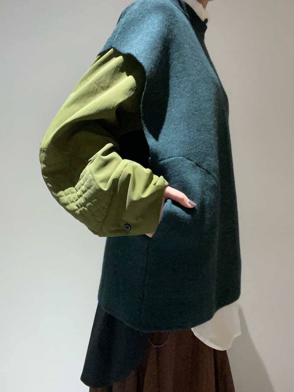 グリーン系のニット/セーター、その他のシャツ/ブラウス、ブラック系のハンドバッグを着用したレディースの秋コーディネートの4枚目の写真