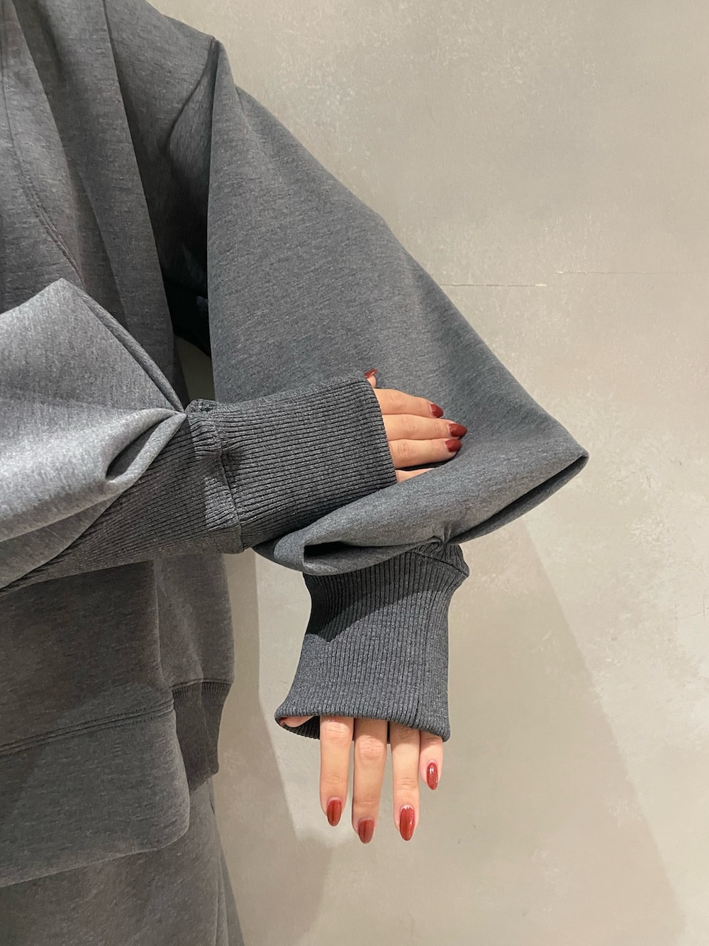 グレー系のニット/セーター、グレー系のTシャツ/カットソー、ブルー系のショルダーバッグを着用したレディースの秋コーディネートの5枚目の写真