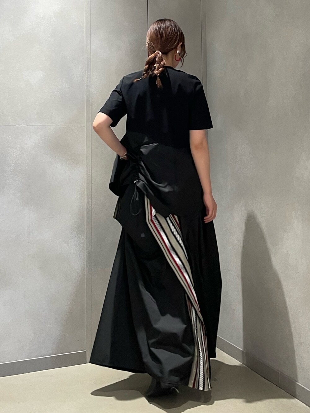 レッド系のTシャツ/カットソー、レッド系のスカート、ブラック系のブーツを着用したレディースの夏コーディネートの3枚目の写真