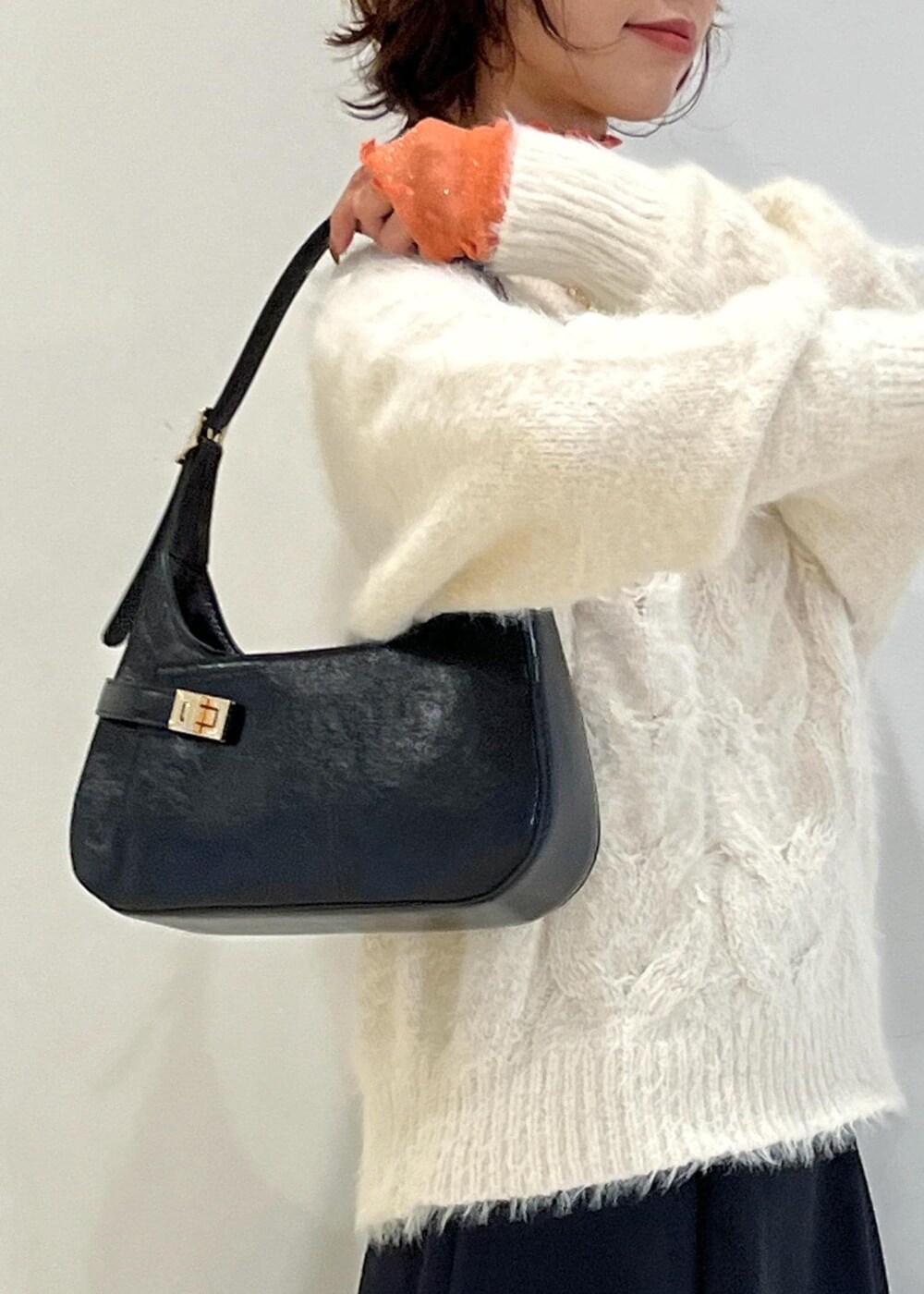 ブラック系のブーツ、ブラック系のハンドバッグ、ブラック系のスカートを着用したレディースの冬コーディネートの9枚目の写真