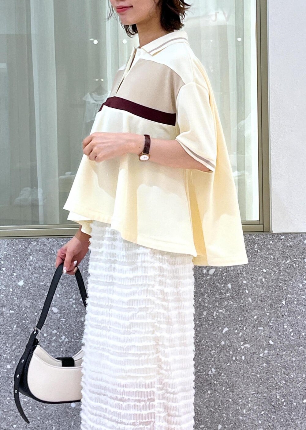 ブラック系のサンダル、ホワイト系のスカート、ベージュ系のポロシャツを着用したレディースの夏コーディネートの9枚目の写真