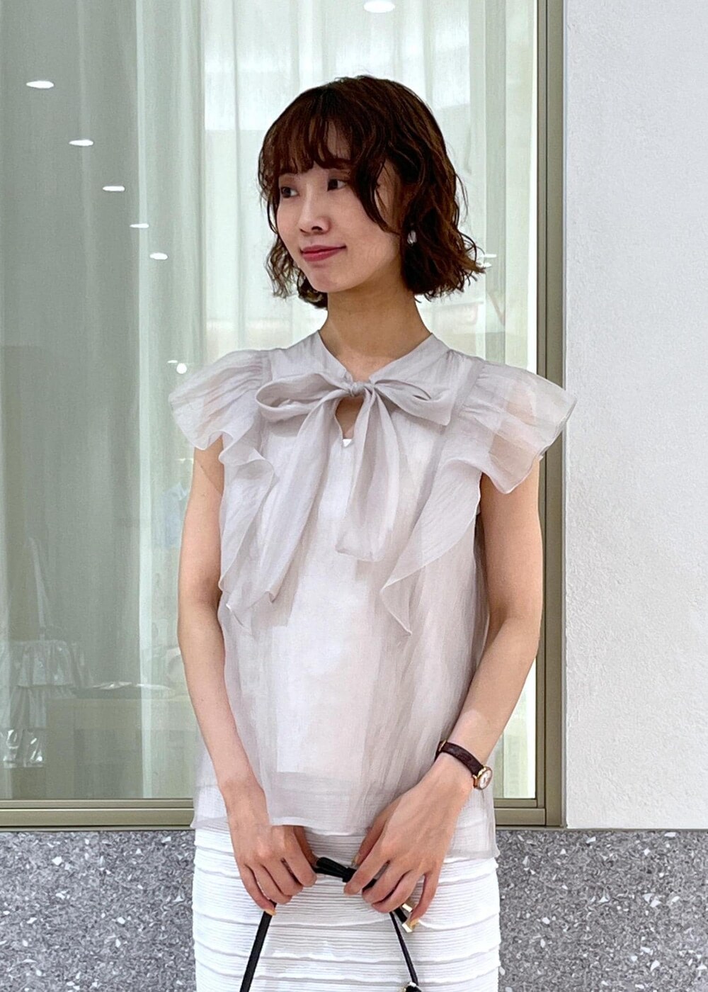 ブラック系のサンダル、ホワイト系のスカート、ホワイト系のキャミソールを着用したレディースの春コーディネートの4枚目の写真