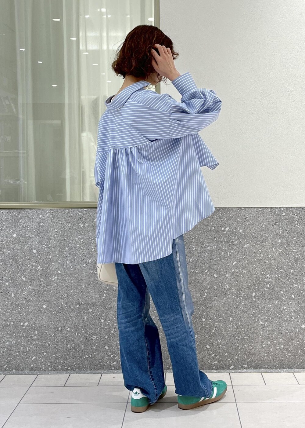 ブルー系のデニムパンツ、ブルー系のシャツ/ブラウス、ホワイト系のボストンバッグを着用したレディースの春コーディネートの3枚目の写真