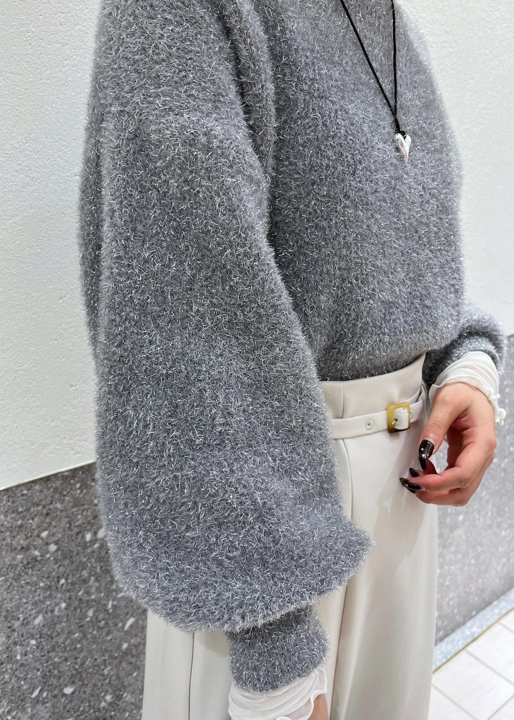 ホワイト系のTシャツ/カットソー、ホワイト系のスカート、グレー系のニット/セーターを着用したレディースの冬コーディネートの5枚目の写真