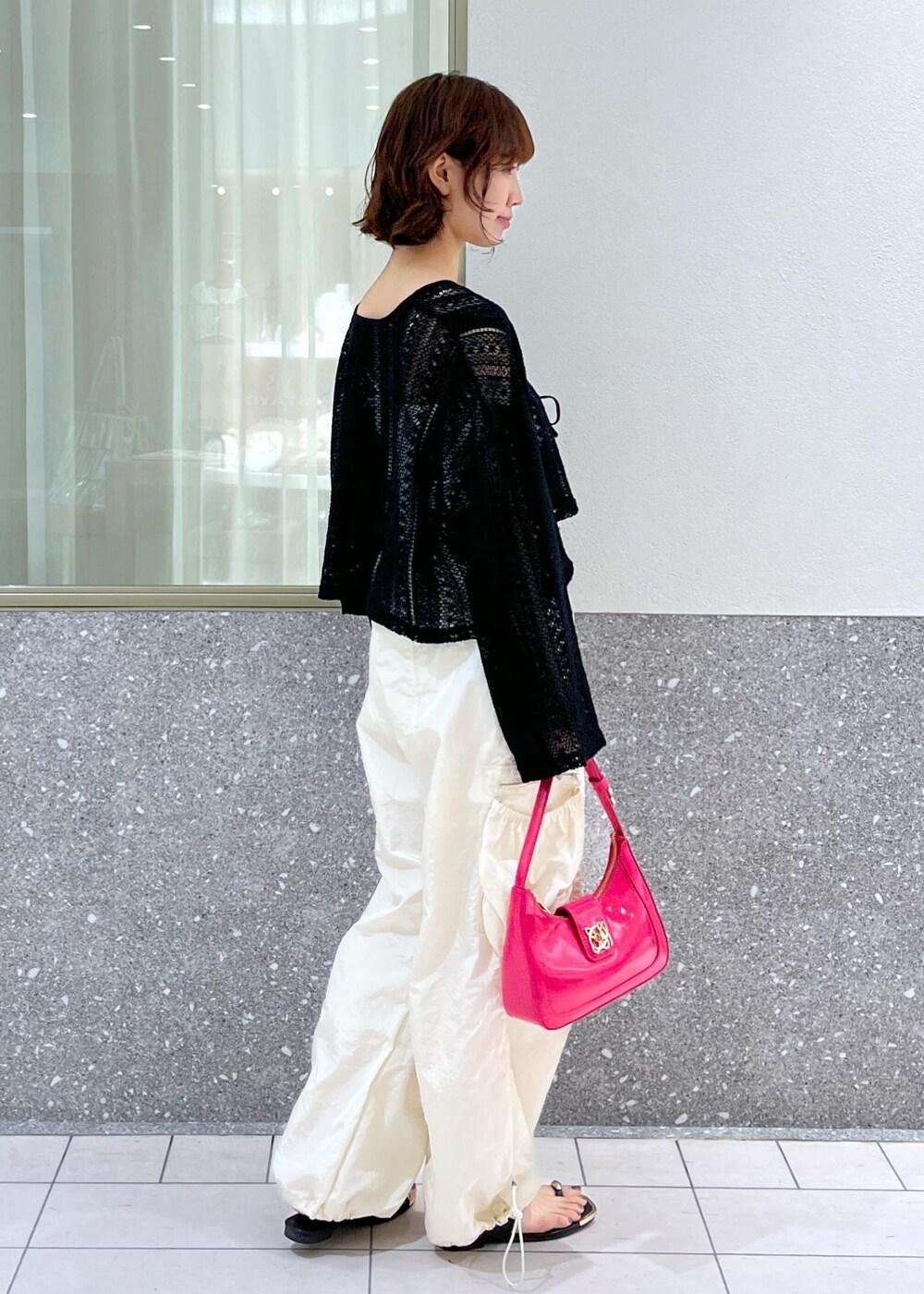 ブラック系のサンダル、ピンク系のハンドバッグ、ブラック系のカーディガン/ボレロを着用したレディースの夏コーディネートの2枚目の写真